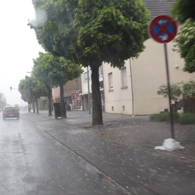 Eine Straße, Regen, Autos und Hagelkörner.