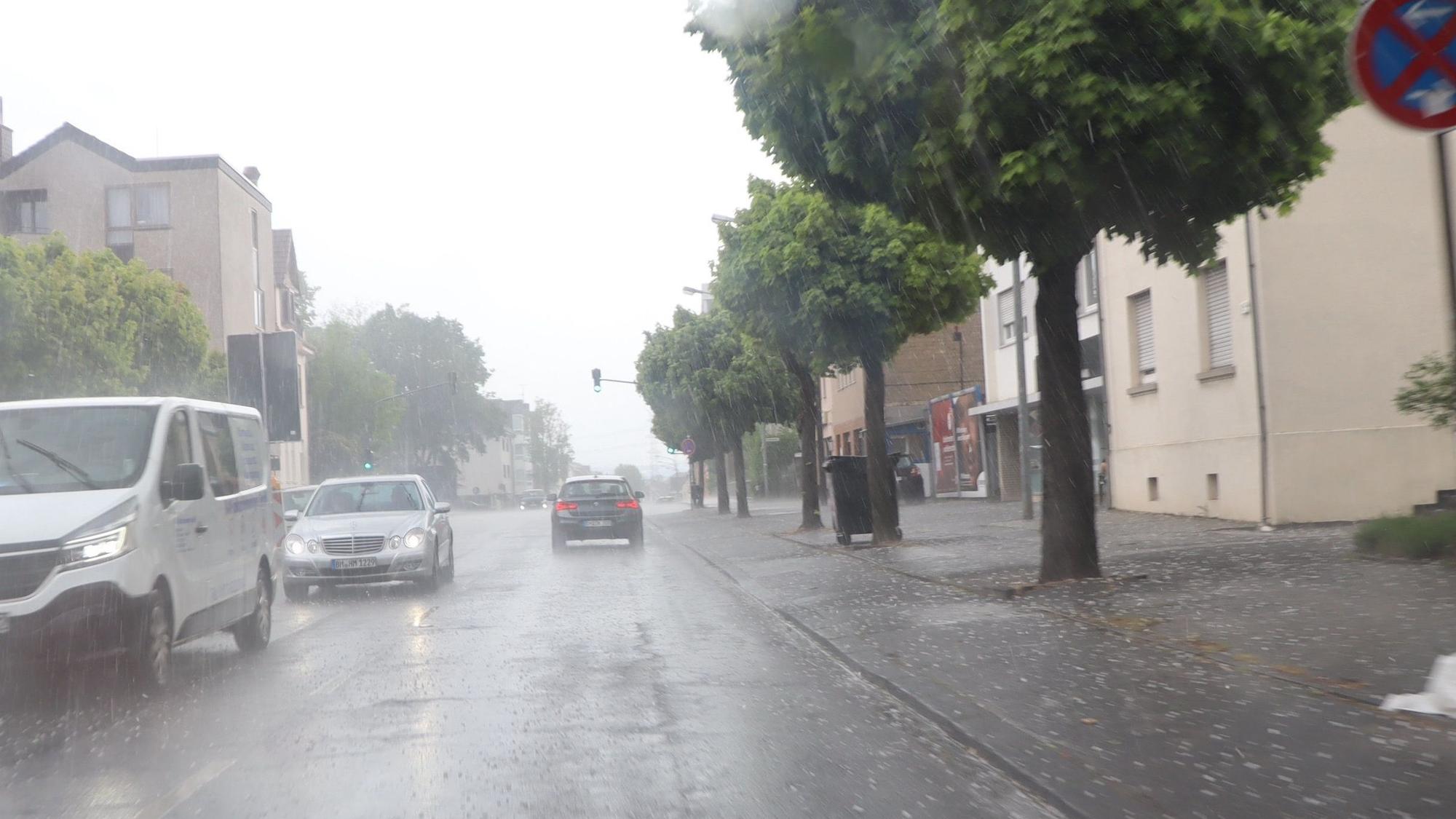 Eine Straße, Regen, Autos und Hagelkörner.