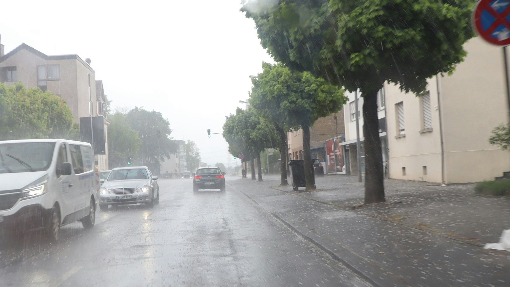 Eine Straße, Regen, Autos und Hagelkörner.