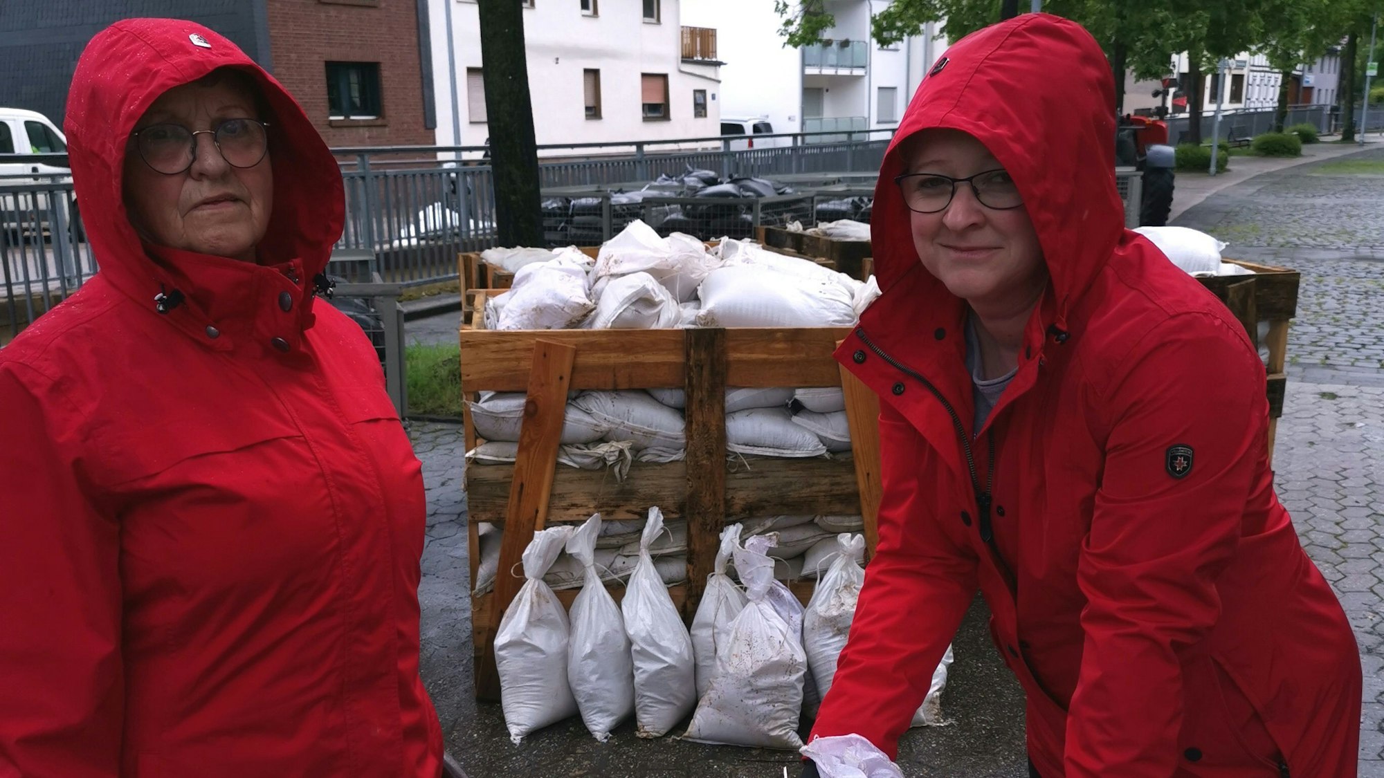 Nach dem Unwetter: Betty und Tanja Brünagel bringen Sandsäcke zurück zum Dorfplatz. Unwetter am 2. Mai 2024.