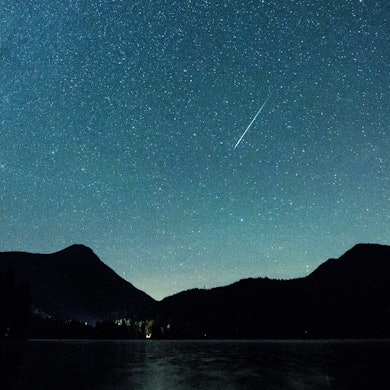 Bayern, Einsiedl: Eine Sternschnuppe leuchtet neben der Milchstraße am Himmel über dem Walchensee. (Archivbild)