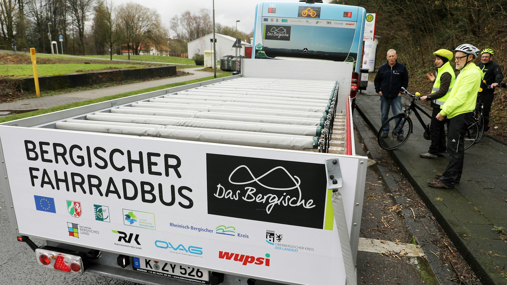 Ein Fahrradanhänger hinter einem Bergischen Fahrradbus steht an einer Haltestelle in Burscheid.