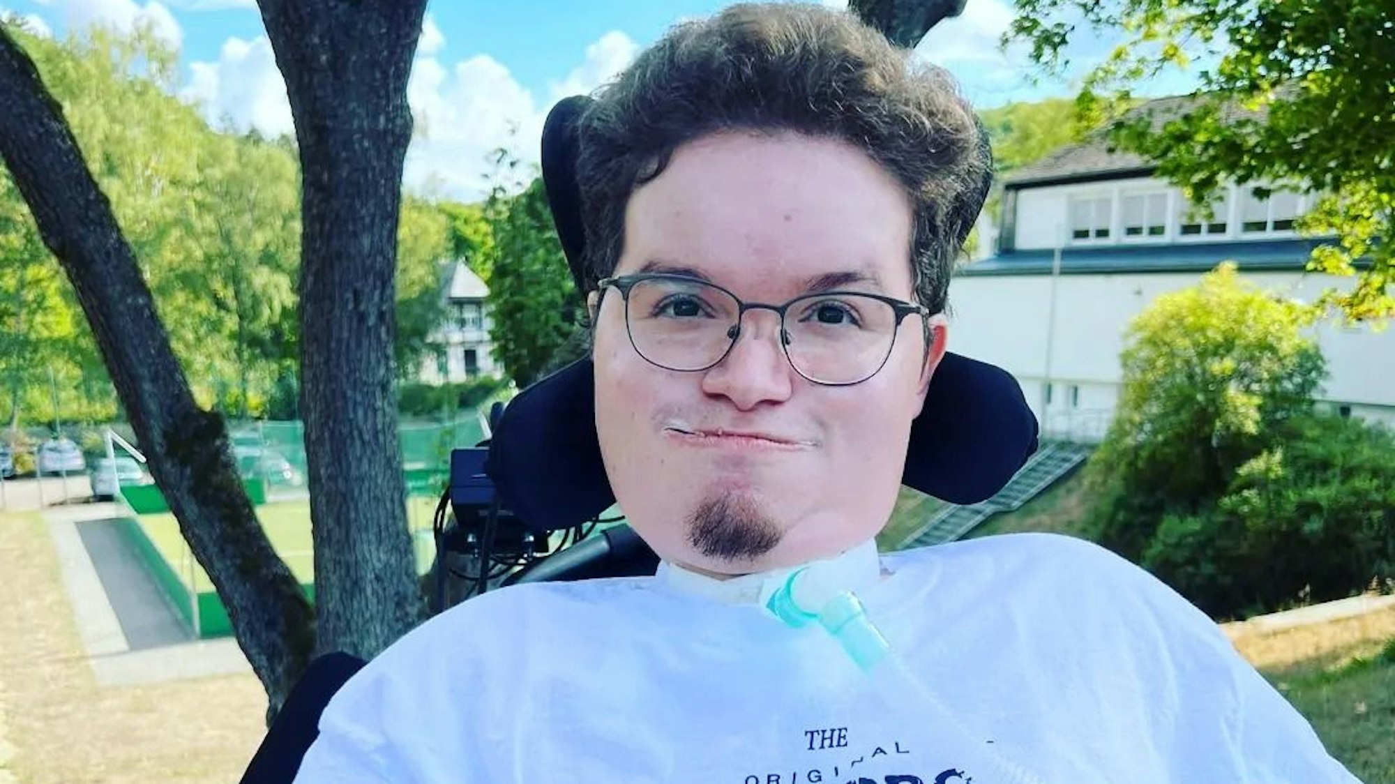 Simon Hellenthal sitzt in seinem Rollstuhl im Garten.