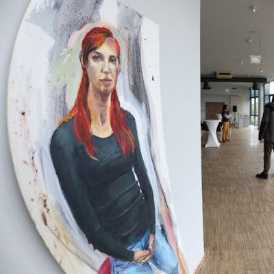 Das Bild „Theaterregisseurin" von Tobias Buß hängt im Eingangsbereich.