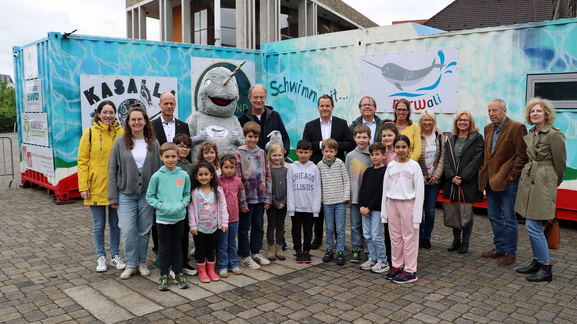 Erwachsene und Kinder stehen vor dem Schwimmcontainer.