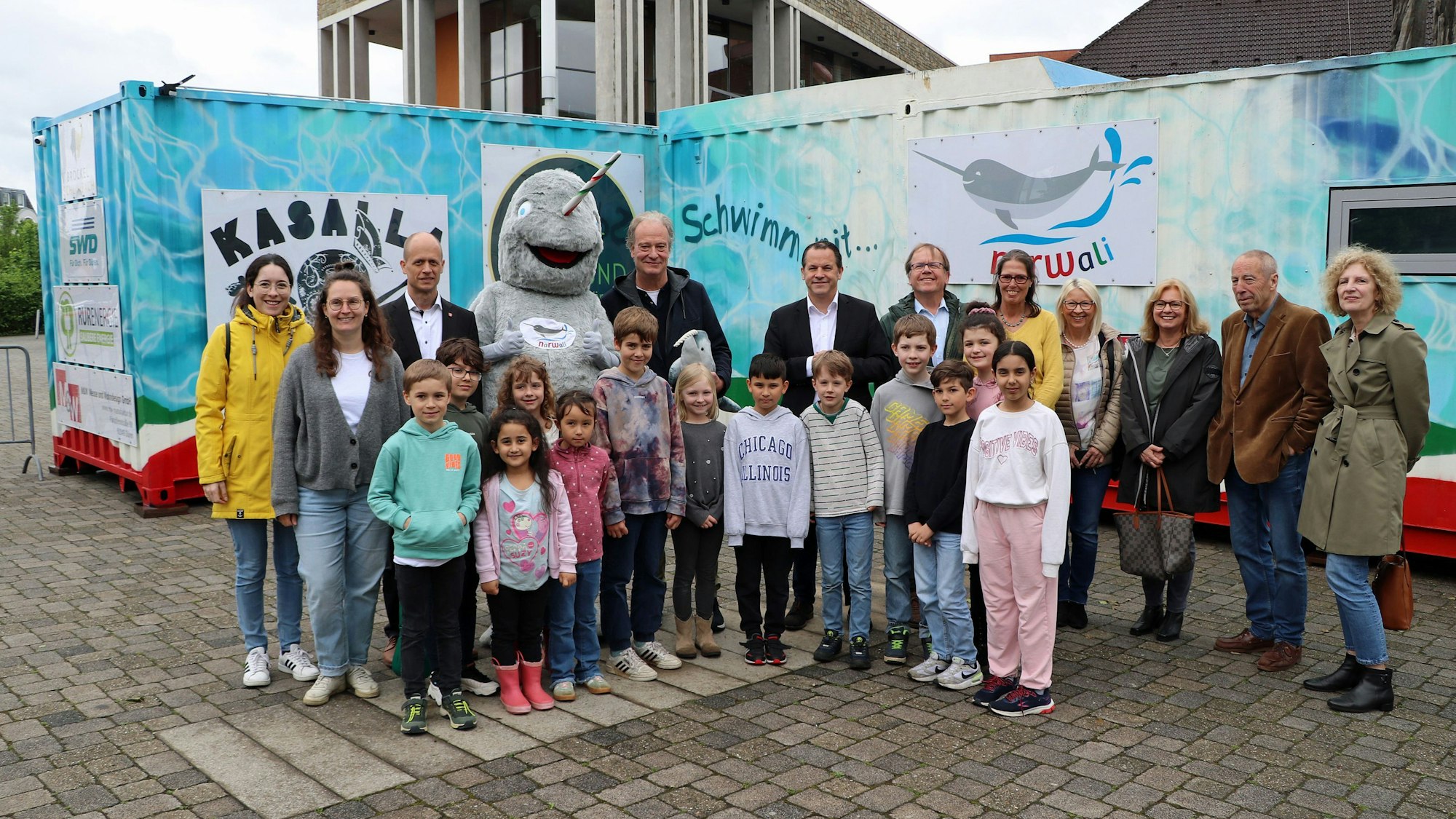 Erwachsene und Kinder stehen vor dem Schwimmcontainer.