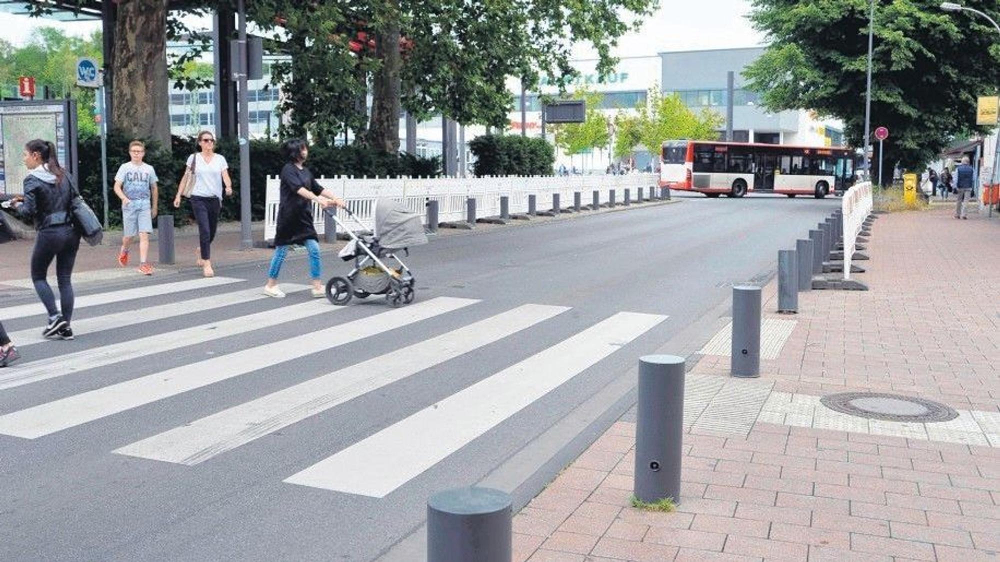 Das Foto zeigt Passanten, die die Stationsstraße überqueren