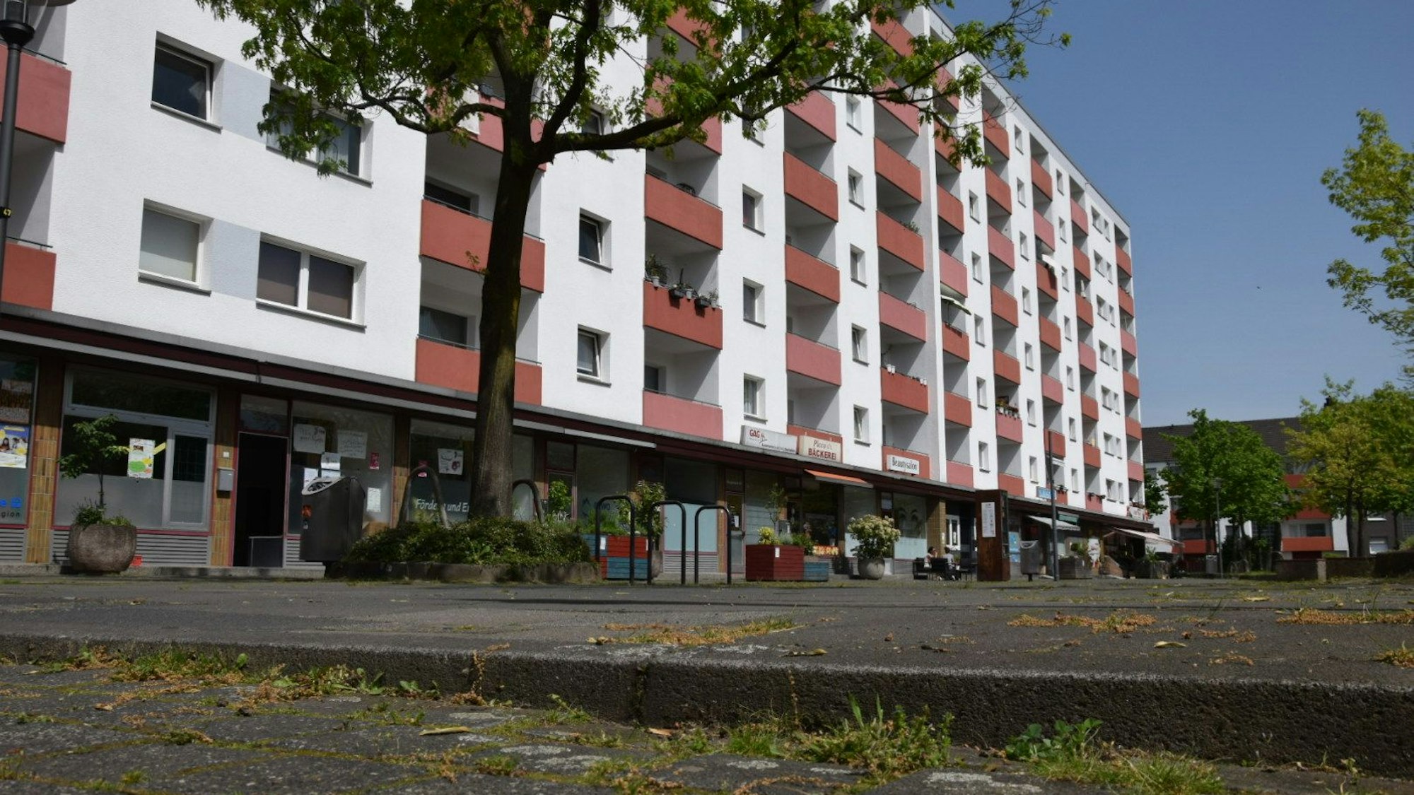 Blick auf den Piccoplatz in Köln-Holweide, der nicht barrierefrei ist. Im Hintergrund ist ein Hochhaus zu sehen. Foto von Rika Kulschewski.