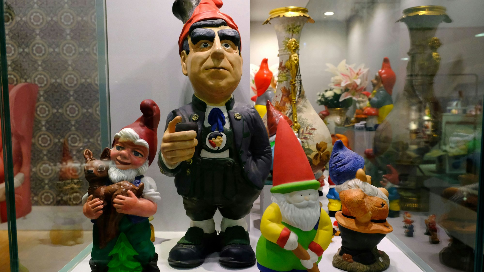 In einer Ausstellungsvitrine sind mehrere Gartenzwerge zu sehen. Einer stellt den Politiker Theo Waigel dar.