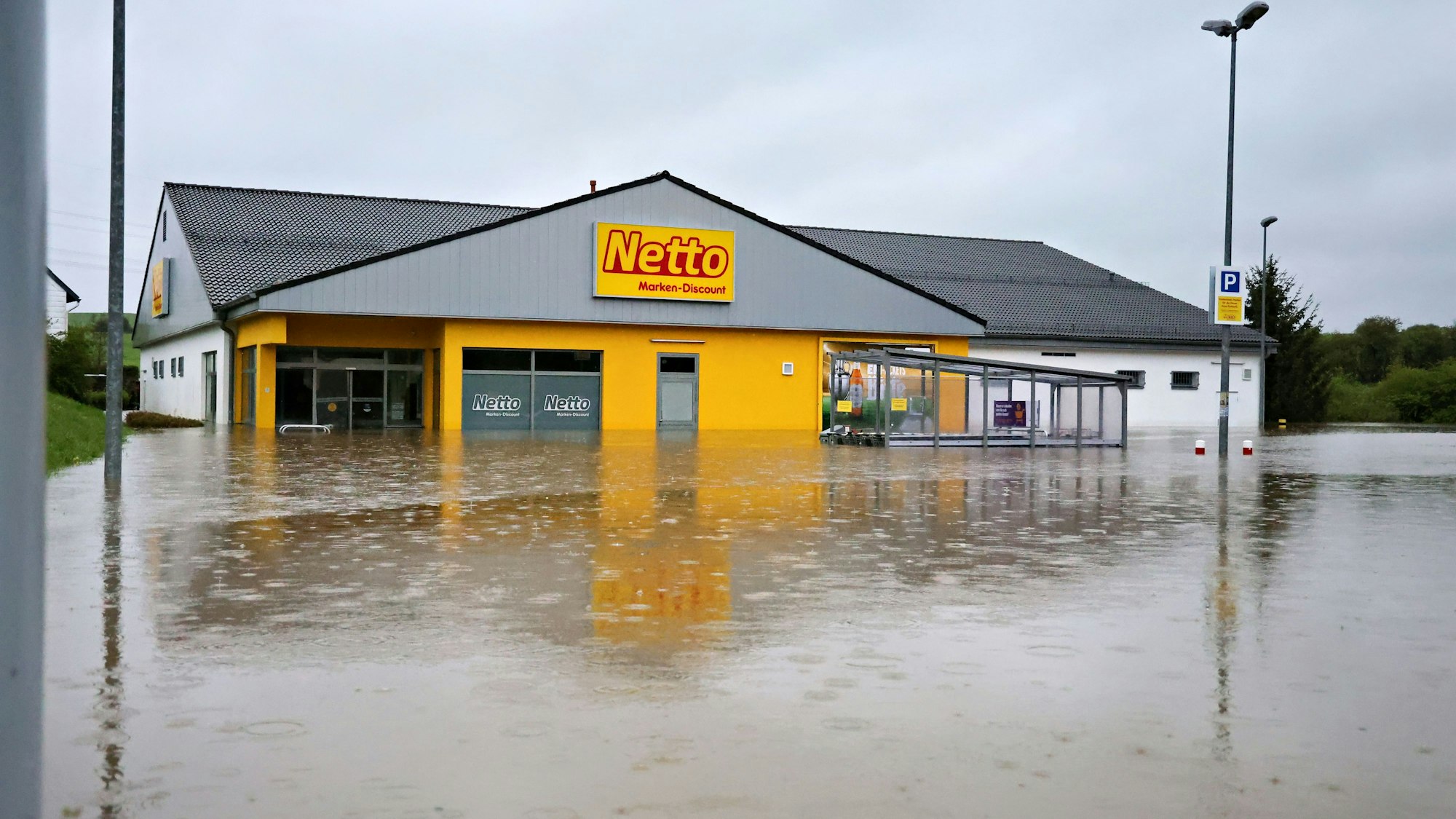 Auf dem Parkplatz ist ein See entstanden. Das Wasser steht vor und im Markt etwa einen Meter hoch.