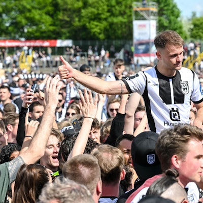04.05.2024, Baden-Württemberg, Ulm: Fußball: 3 Liga, SSV Ulm 1846 Fussball - FC Viktoria Köln im Donaustadion. Ulms Leo Scienza feiert mit den Fans den Aufstieg. Foto: Harry Langer/DeFodi Images/dpa - WICHTIGER HINWEIS: Gemäß den Vorgaben der DFL Deutsche Fußball Liga bzw. des DFB Deutscher Fußball-Bund ist es untersagt, in dem Stadion und/oder vom Spiel angefertigte Fotoaufnahmen in Form von Sequenzbildern und/oder videoähnlichen Fotostrecken zu verwerten bzw. verwerten zu lassen. +++ dpa-Bildfunk +++