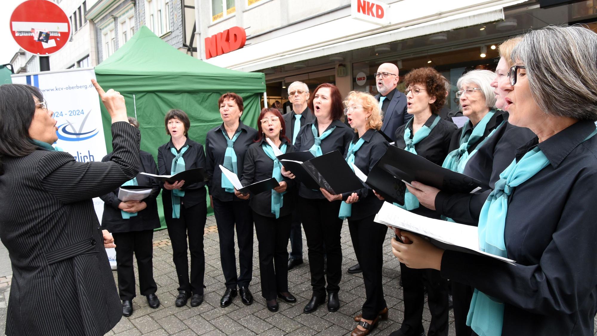 Ein Frauenchor singt vor dem Ladengeschäft NKD.