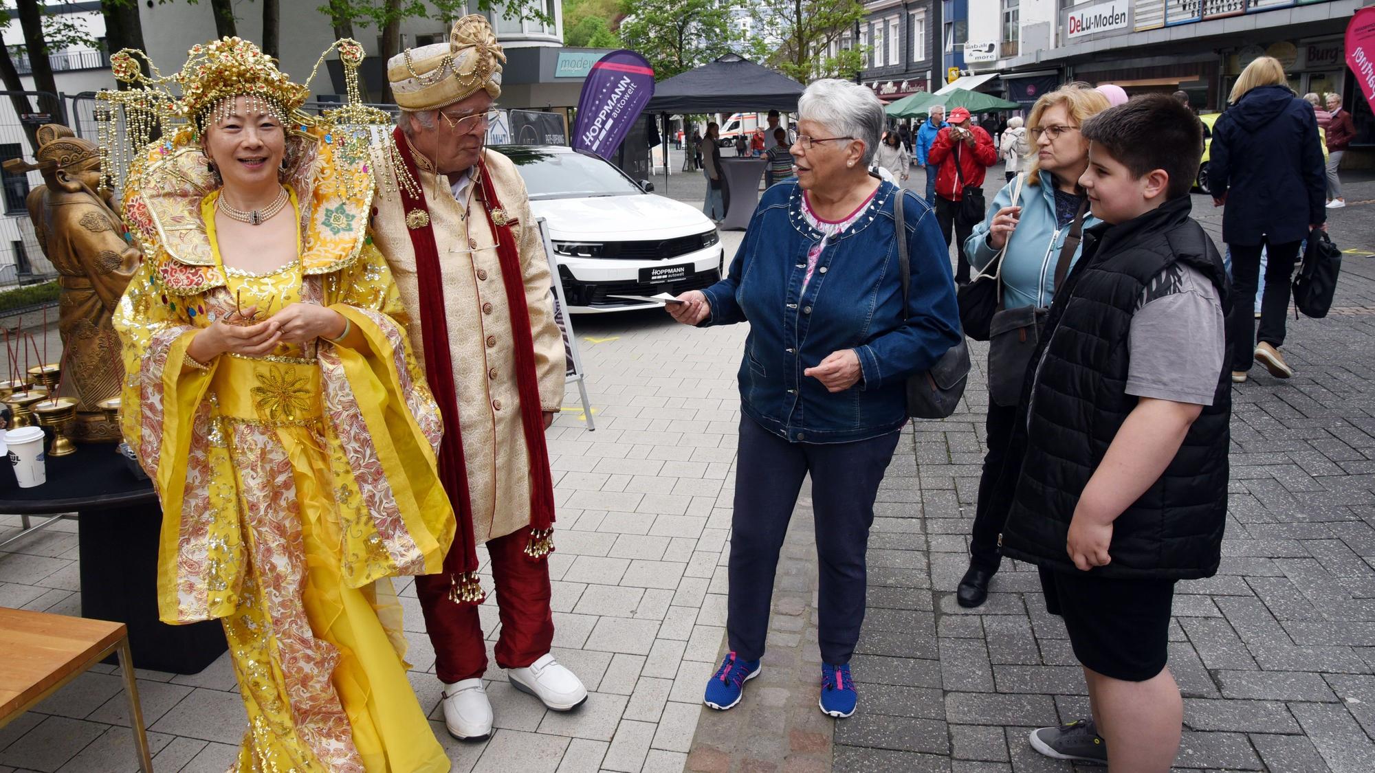 Ein Paar in chinesischer Festtracht wird von Passanten bewundert.