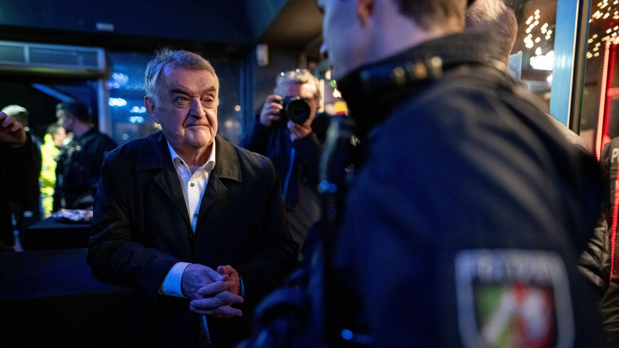 Herbert Reul (CDU, l), Innenminister von Nordrhein-Westfalen, unterhält sich mit Beamten in einem Club in Essen.