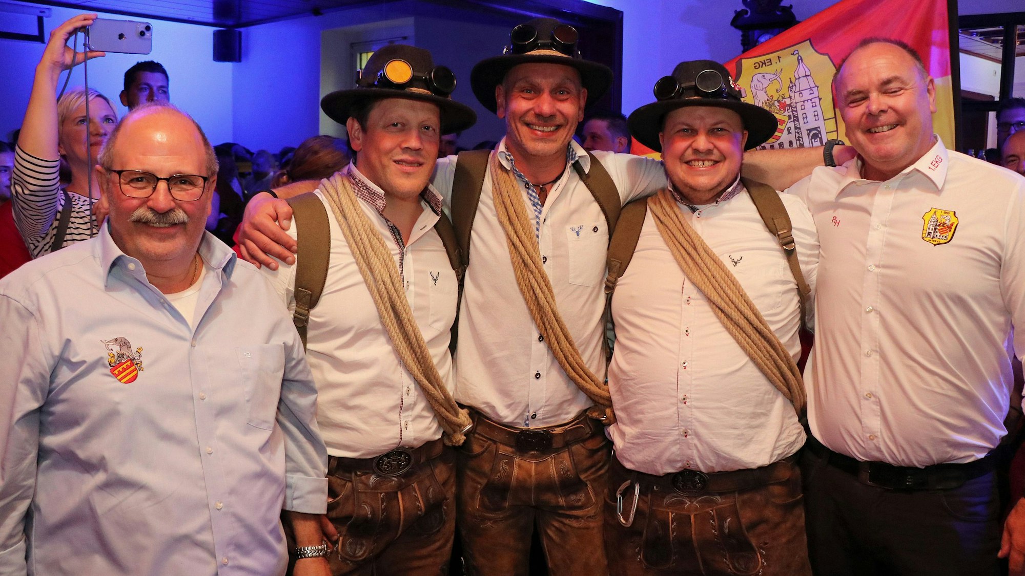 Auf dem Bild ist das neue Dreigestirn mit Vereinsmitgliedern zu sehen.