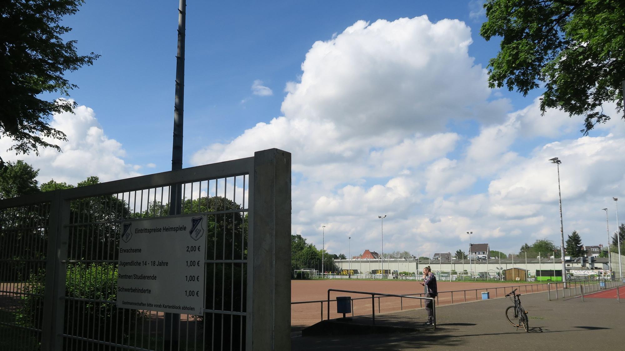 Zu sehen ist der Eingangsbereich der Sportanlage, die die Brachfläche umgibt. Hier trainiert und spielt unter anderem die Germania Ossendorf. Foto von Hans-Willi Hermans