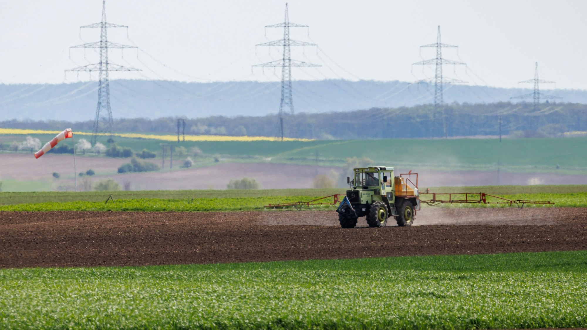 Ein Landwirt bewirtschaftet ein Feld mit einem Traktor.