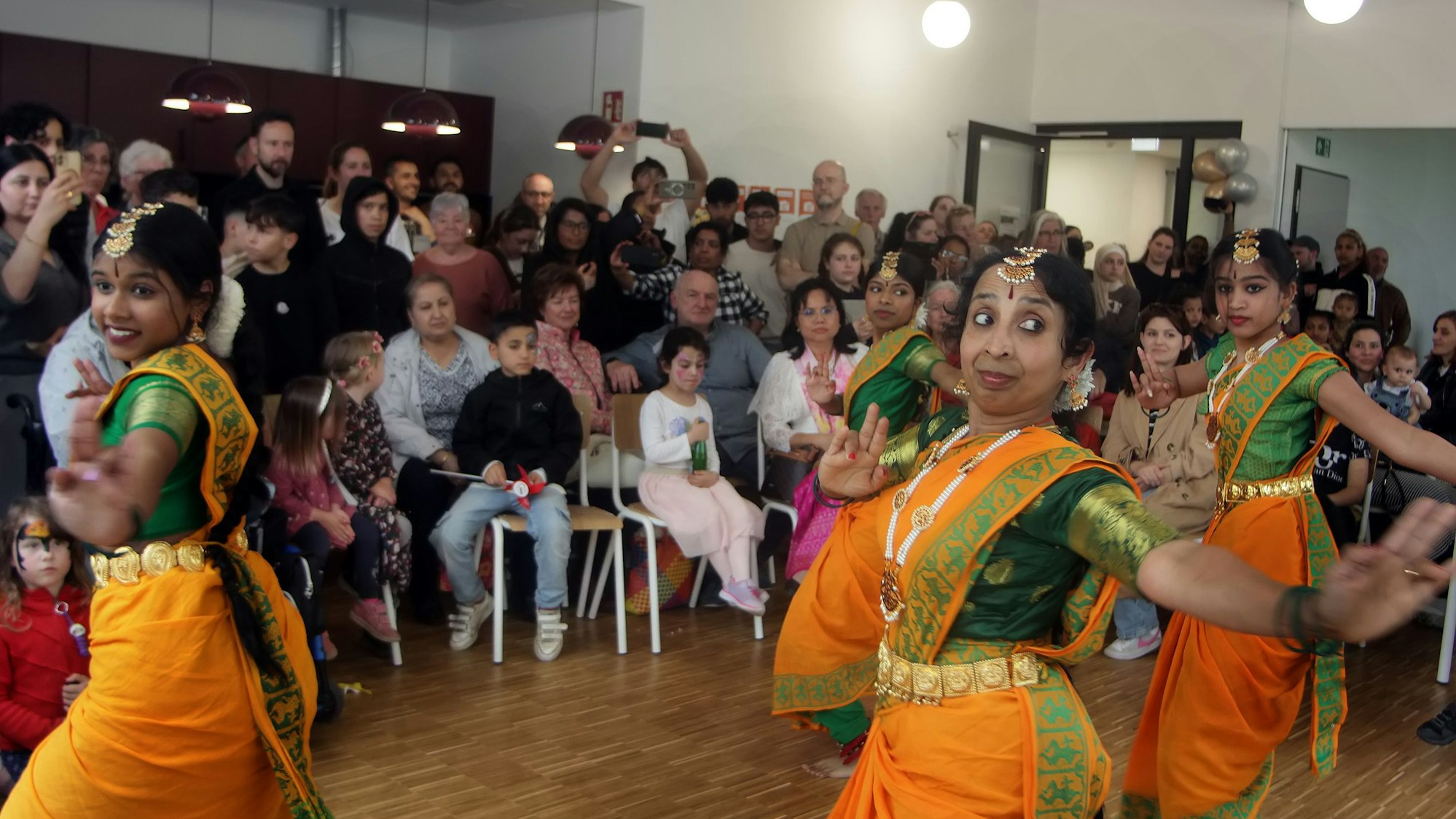 Tamilische Tänzerinnen präsentieren in traditionellen Kleidern einen Tanz im Mosaik.