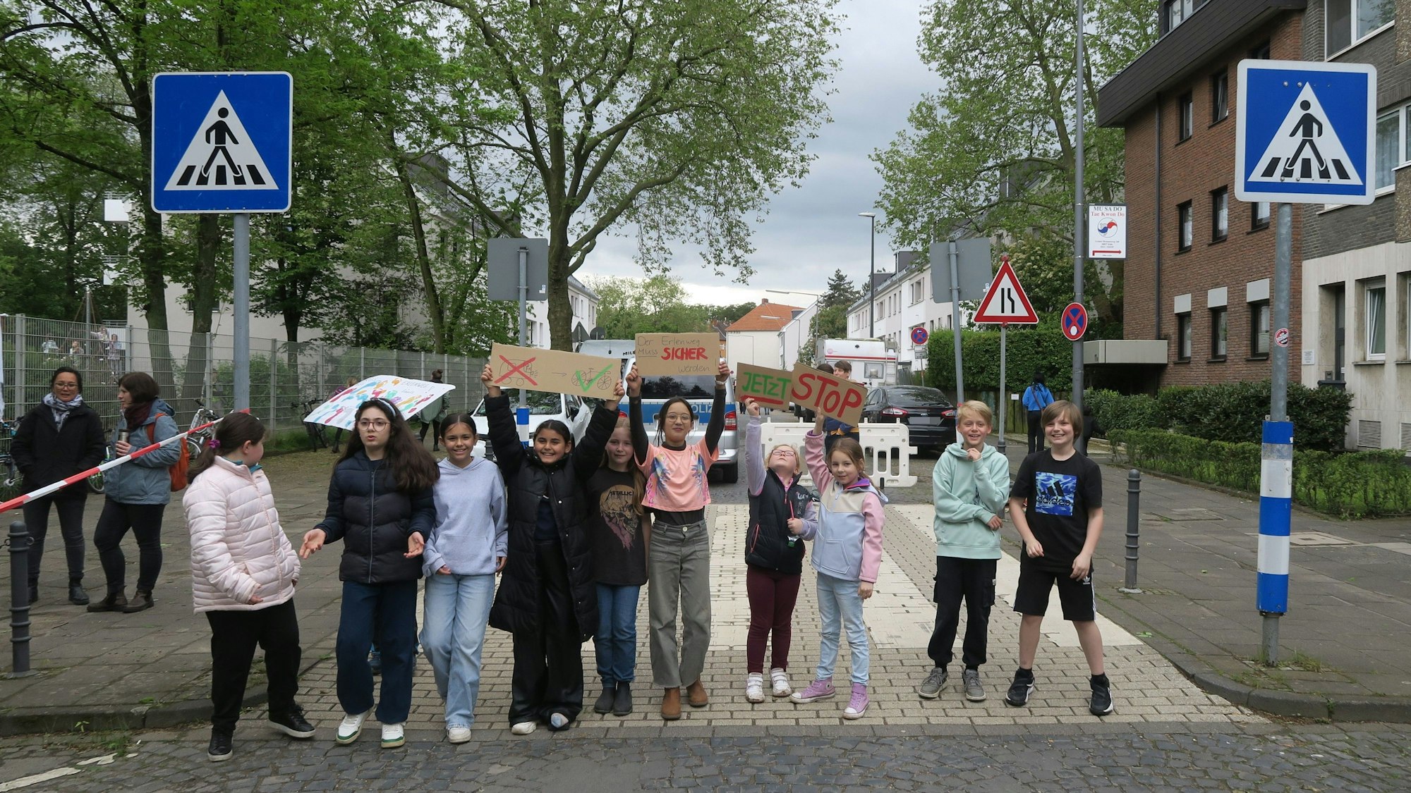 Mehrere Kinder stehen auf dem gesperrten Erlenweg in Bickendorf bei ihrer Kundgebung gegen Elterntaxis und gefährliche Verkehrssituationen. Foto von Hans-Willi Hermans