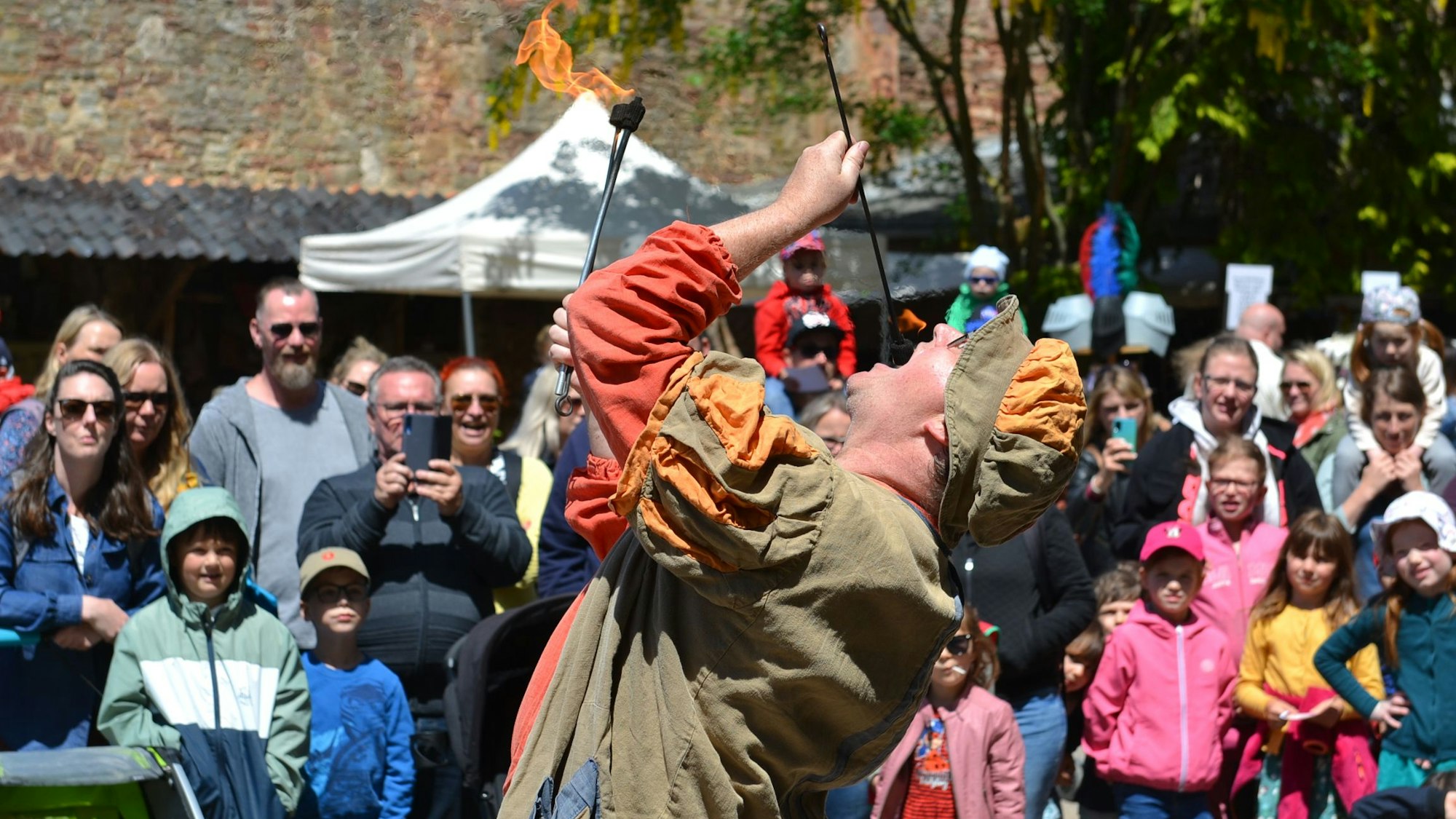 Ein Feuerschlucker tritt vor Publikum auf.