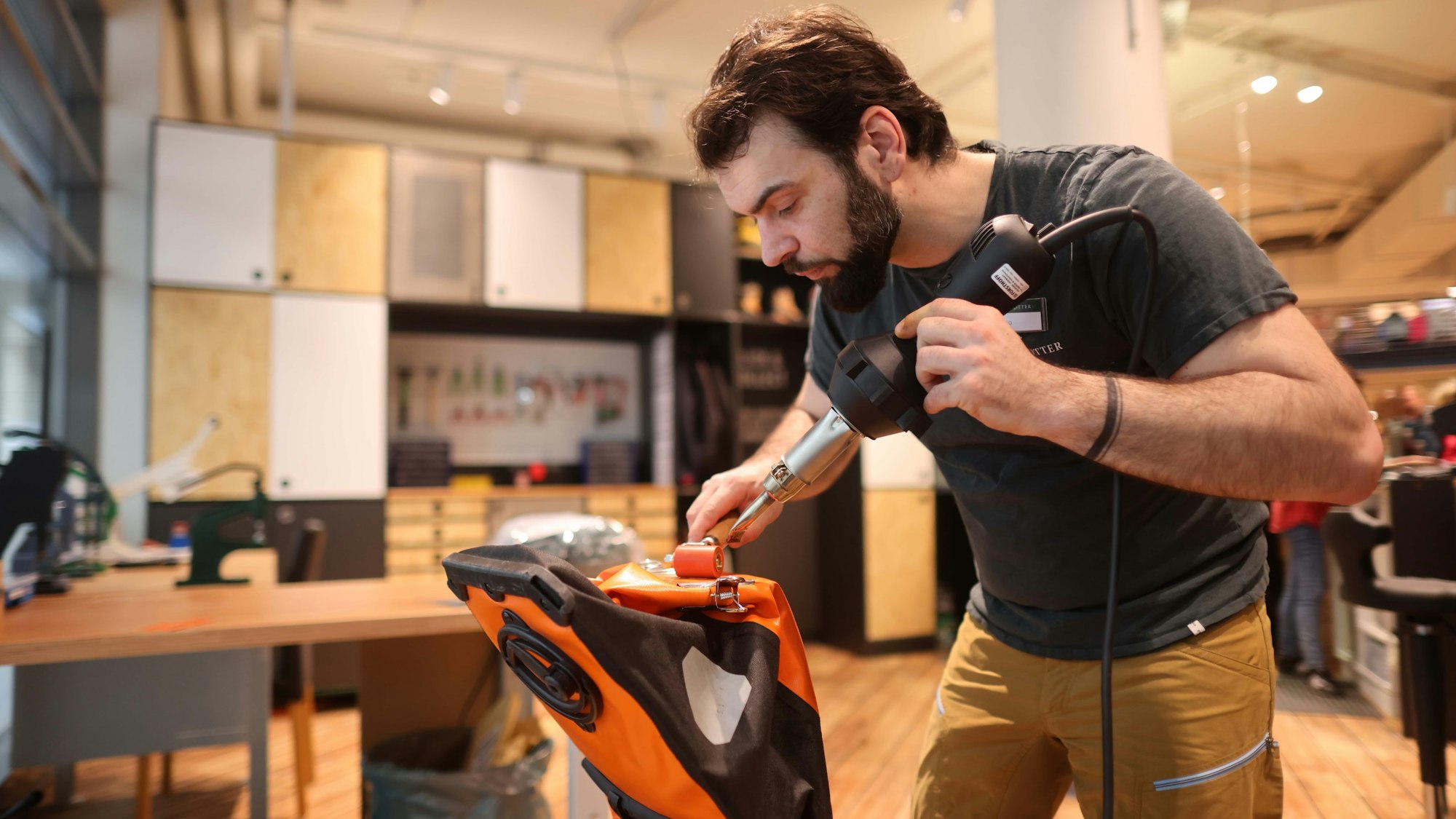 Angestellter von Globetrotter repariert einen Rucksack.