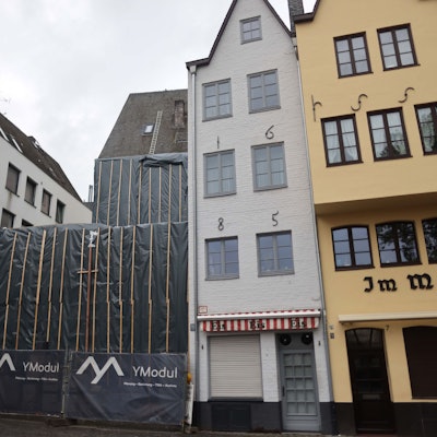 Hinter grauen Planen verborgen liegen die Überreste der beiden historischen Fachwerkhäuser am Kölner Fischmarkt.