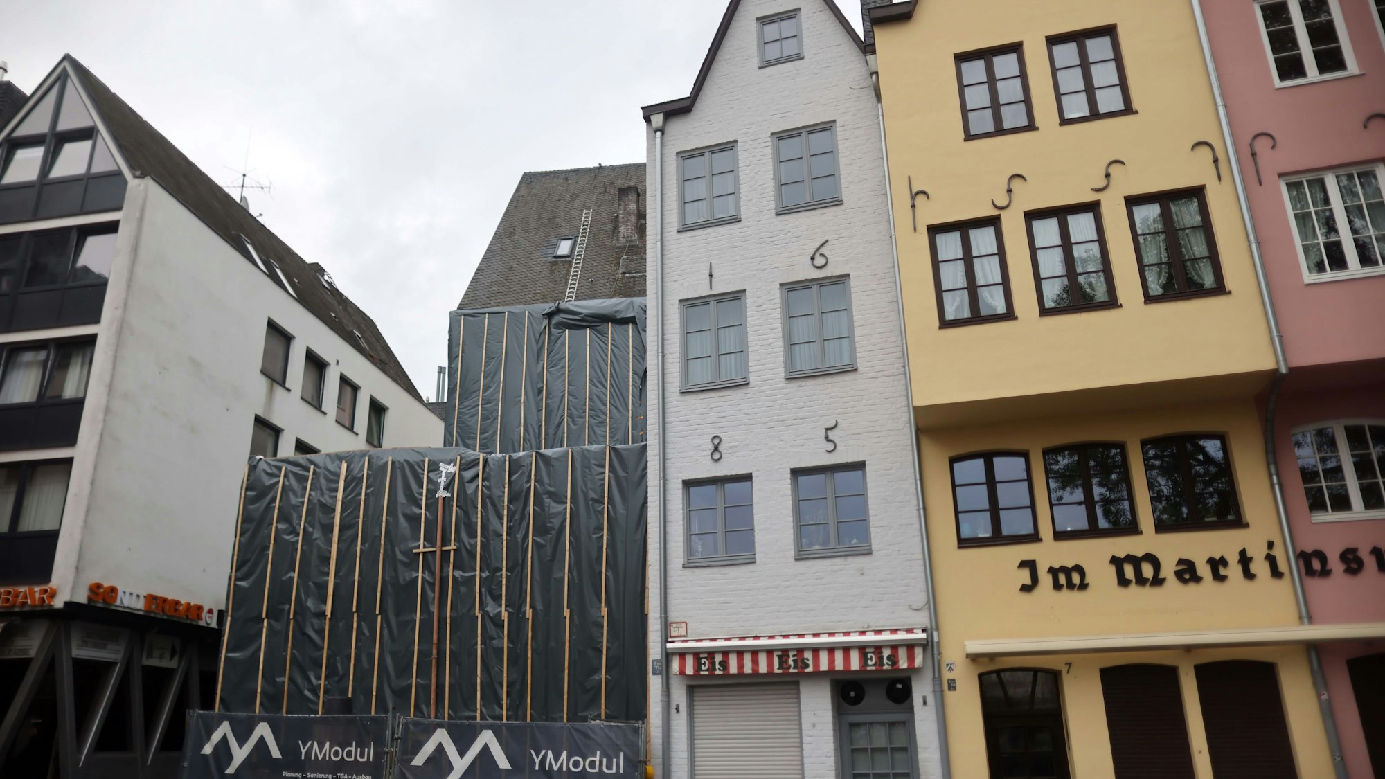 Hinter grauen Planen verborgen liegen die Überreste der beiden historischen Fachwerkhäuser am Kölner Fischmarkt.