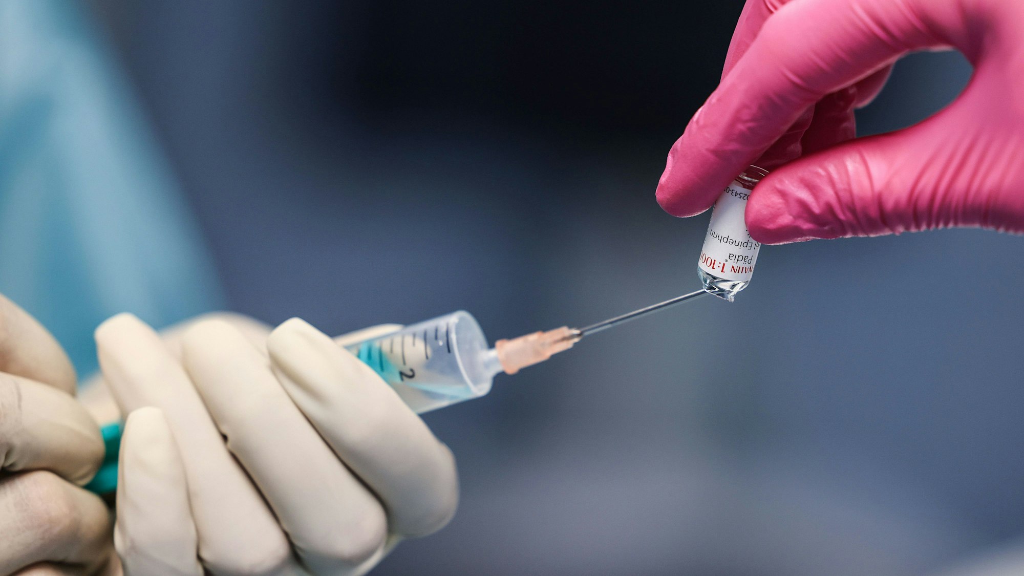 PRODUKTION - 02.05.2023, Nordrhein-Westfalen, Köln: Eine OP-Schwester zieht im Operationssaal eine Spritze für eine Narkose auf. Immer mehr Frauen Anfang 20 wünschen sich ein geradezu hageres Gesicht. Inspiriert von Schönheiten auf Social Media gehen sie dafür sogar zum Schönheitschirurgen. Doch der Eingriff namens Buccal Fat Removal birgt Risiken. (Zu dpa: «Buccal Fat Removal - «Junge Menschen unbedingt davon abhalten»») Foto: Oliver Berg/dpa +++ dpa-Bildfunk +++