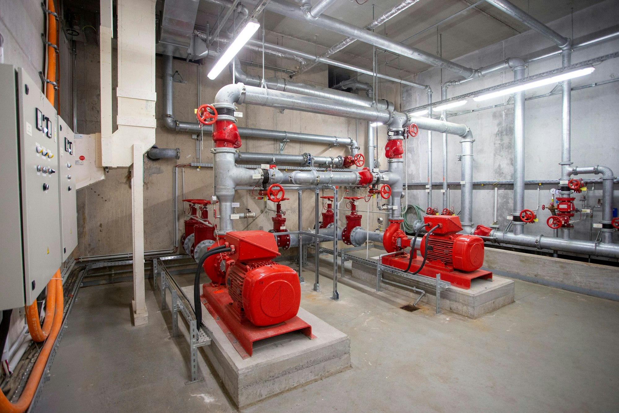In einem Keller der Kölner Messe sind Pumpen und Leitungen zu sehen, die die Sprinkleranlage im Falle eines Feuers mit Wasser versorgen.
