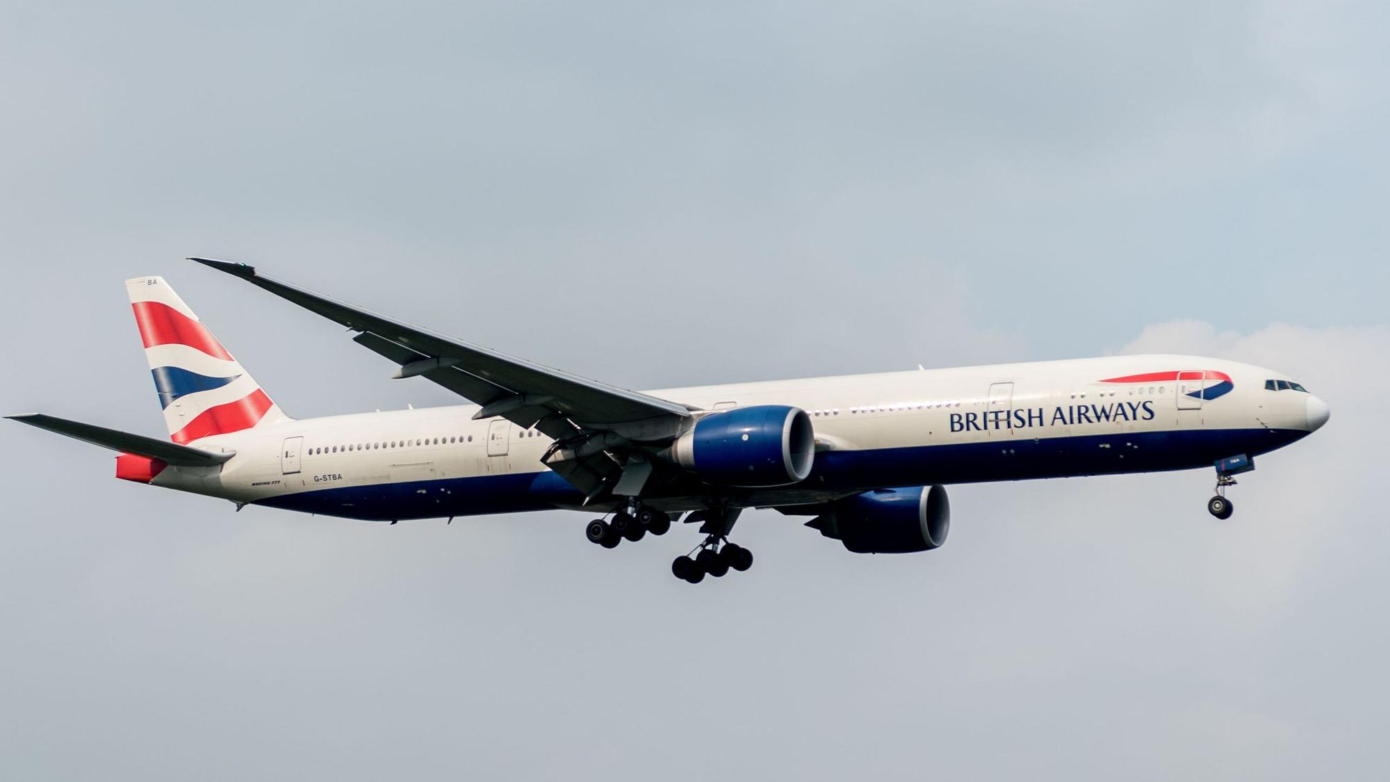 Eine Boeing 777 der britischen Fluggesellschaft British Airways kurz nach dem Start am bewölkten Himmel. Das Flugzeug ist markant in blau, weiß und rot lackiert. (Symbolbild)