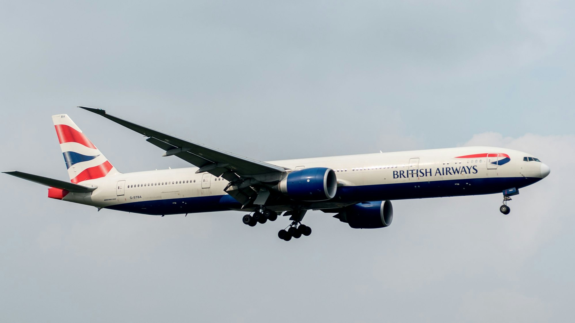 Eine Boeing 777 der britischen Fluggesellschaft British Airways kurz nach dem Start am bewölkten Himmel. Das Flugzeug ist markant in blau, weiß und rot lackiert. (Symbolbild)