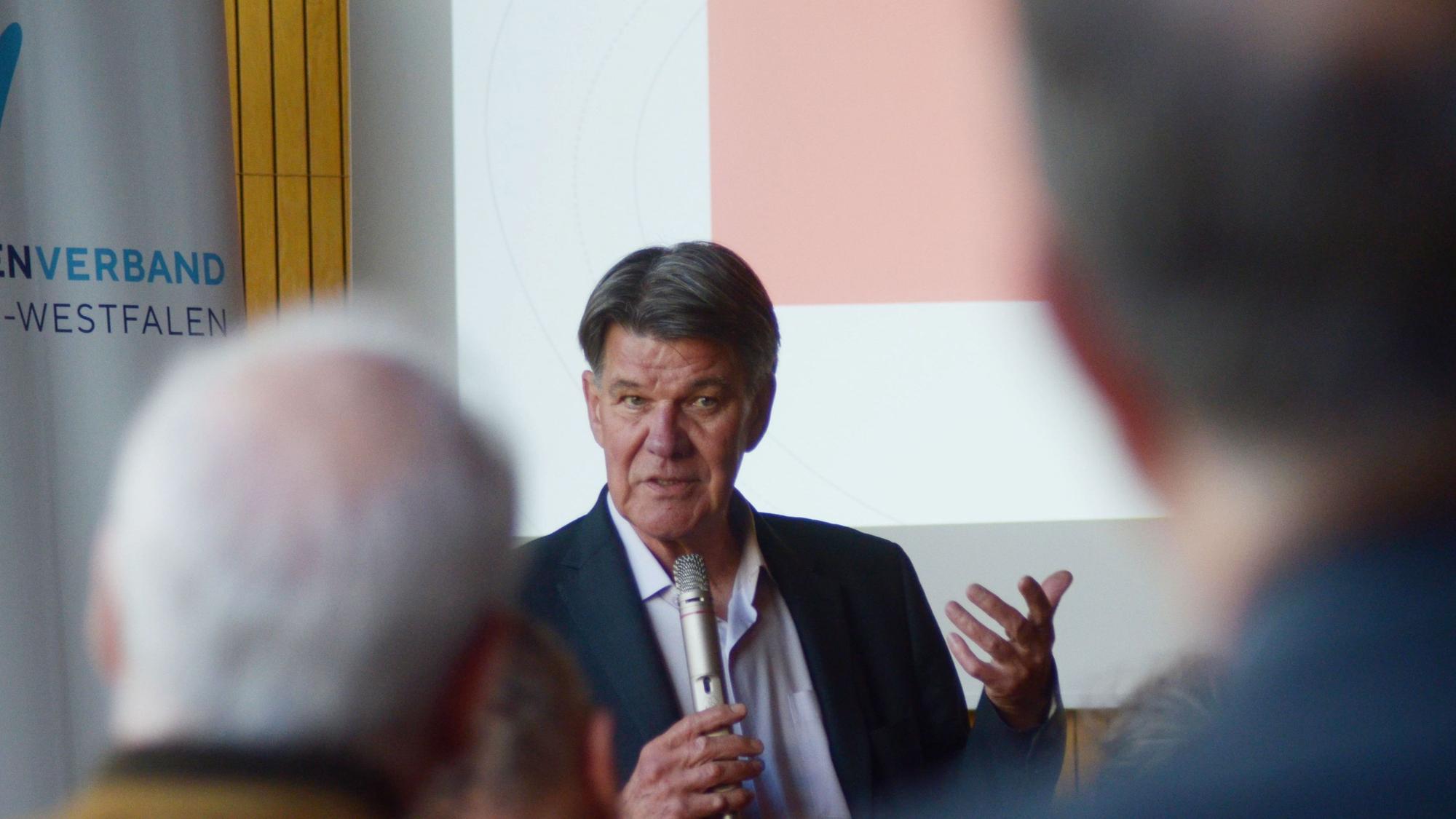 Udo Lielischkies spricht mit einem Mikrofon in der Hand zu seinem Publikum.
