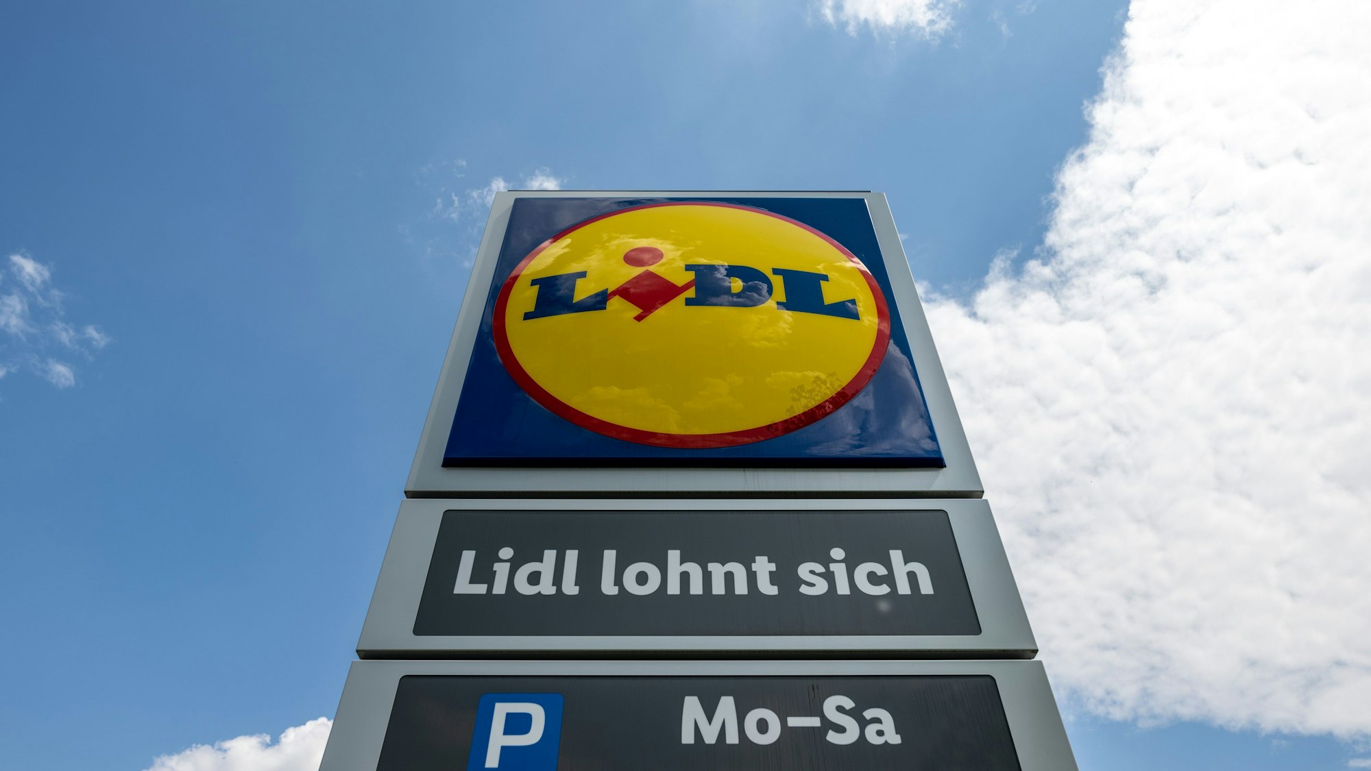 Eine Stele mit dem Logo des Discounters Lidl steht vor einer Filiale.
