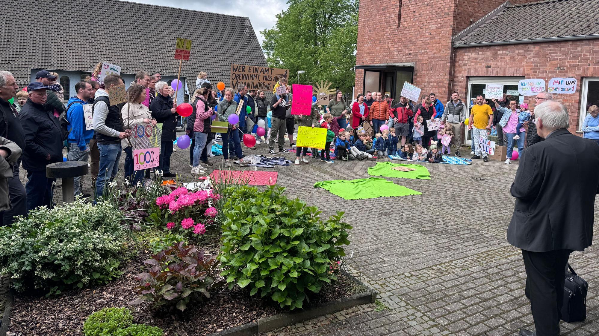Die Elternschaft der Kita St. Rochus protestierte auf dem Kirchplatz, forderte verlässliche Betreuung und bessere Kommunikation.