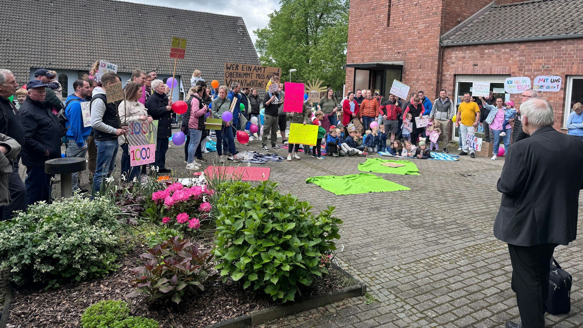 Die Elternschaft der Kita St. Rochus protestierte auf dem Kirchplatz, forderte verlässliche Betreuung und bessere Kommunikation.