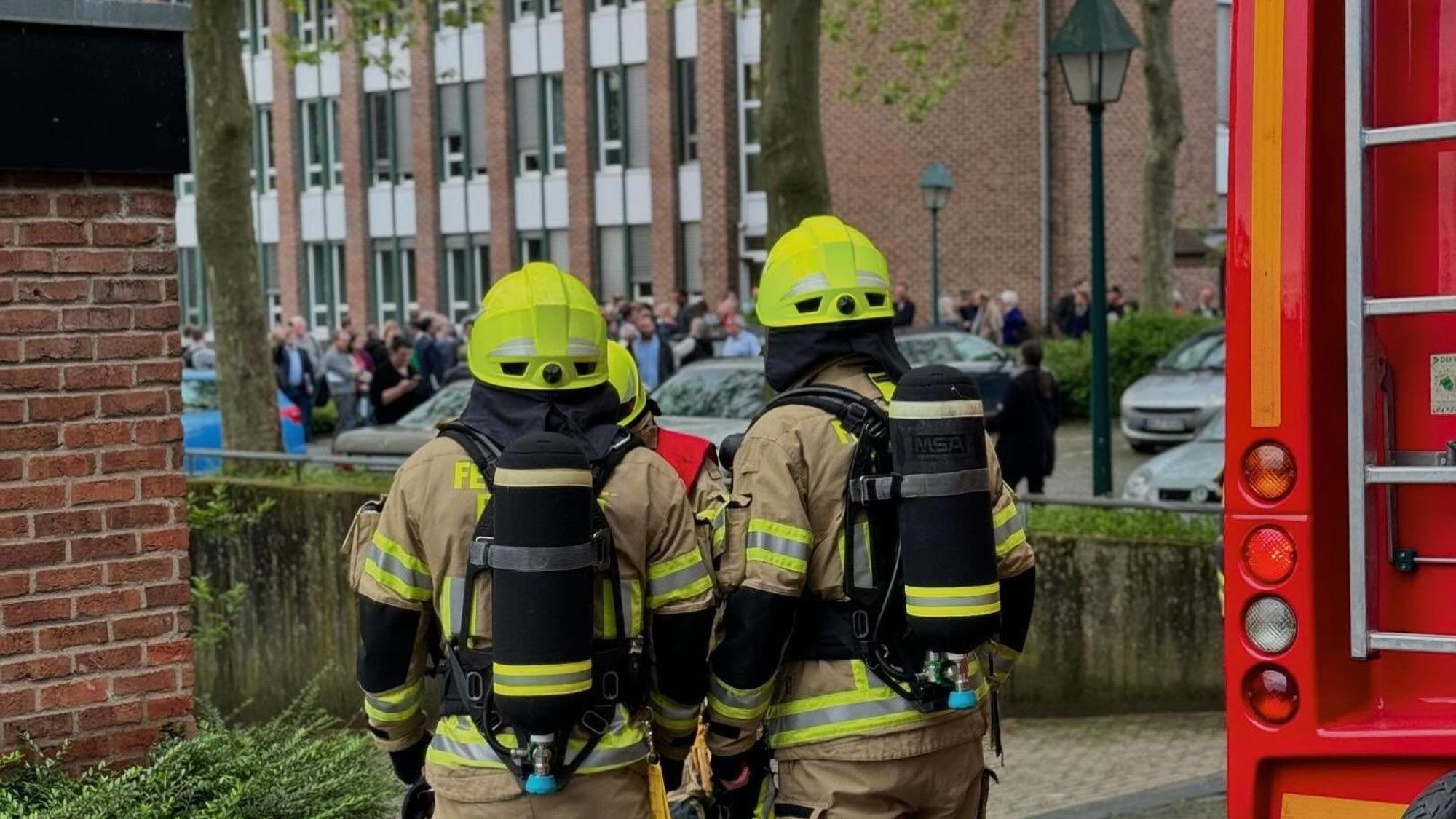 Ratsmitglieder, Angehörige der Stadtverwaltung Pulheim und Besucher warteten vor dem Rathaus, bis die Feuerwehr Entwarnung geben konnte.