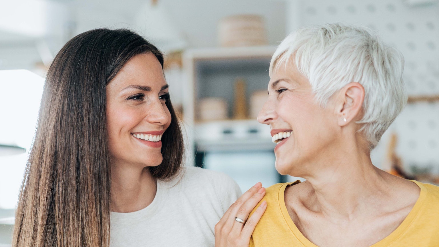 Junge und ältere Frau lächeln sich an.