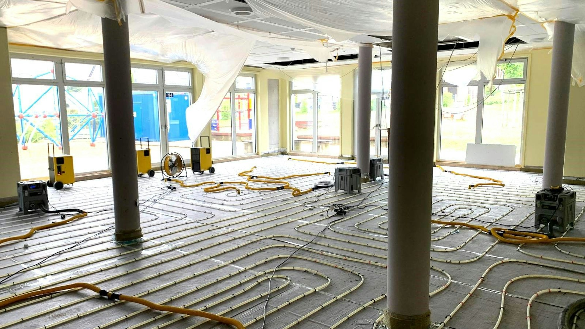 In der Mensa stehen Trockner zwischen den Schleifen der Fußbodenheizung.