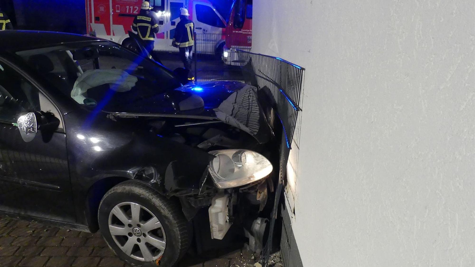 Das Auto mit eingedrückter Front an der Mauer.