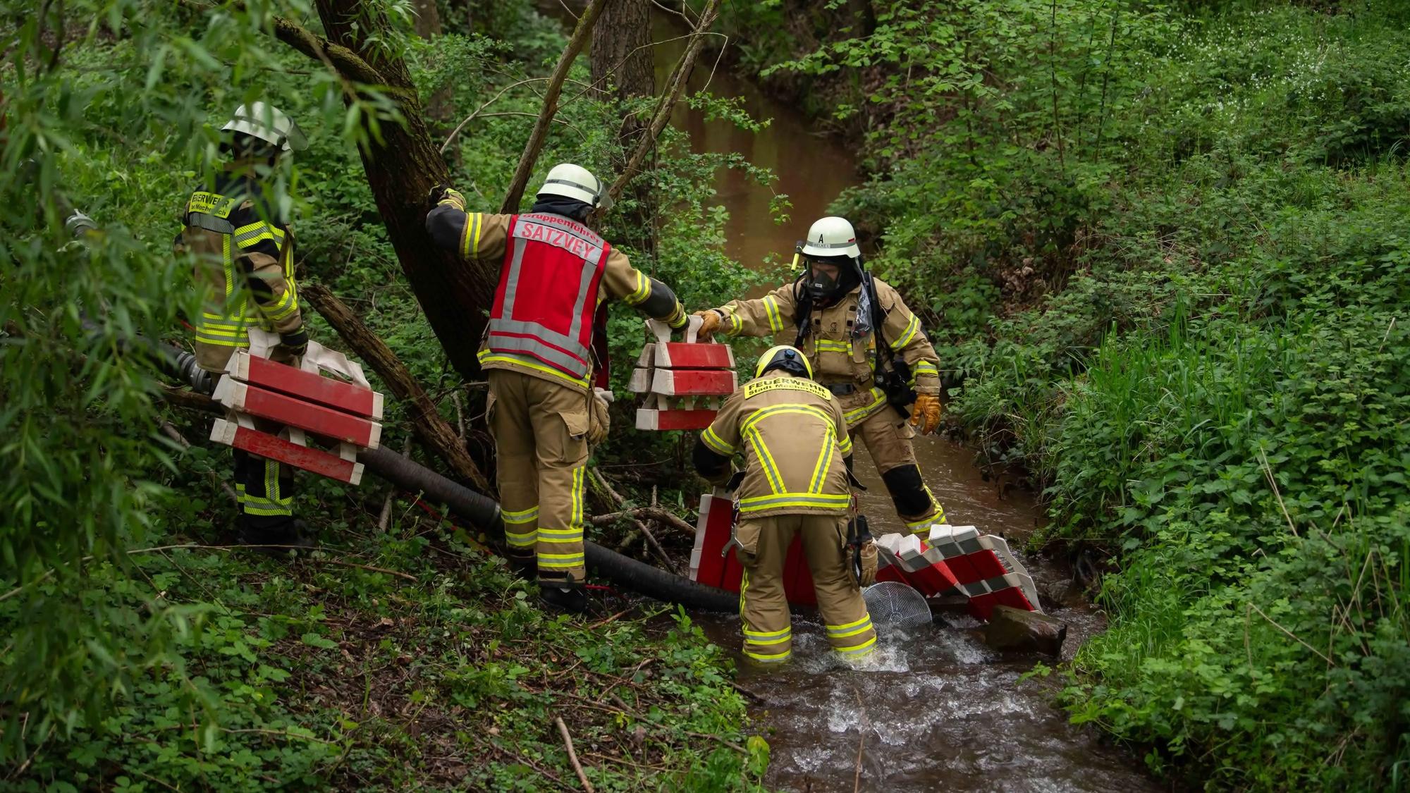 Das Bild zeigt einige Feuerwehrleute im Uferbereich des Bleibachs.