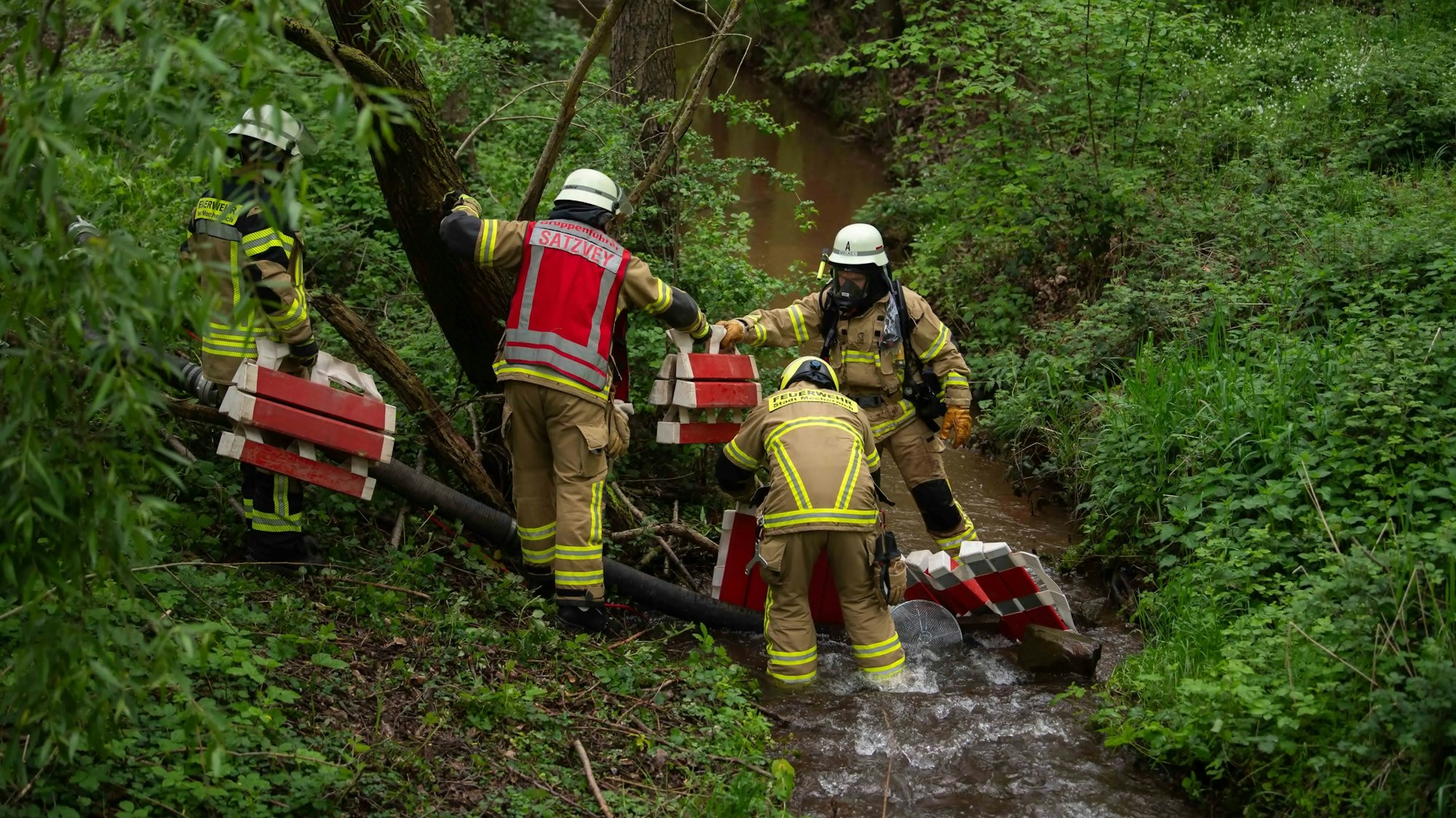 Das Bild zeigt einige Feuerwehrleute im Uferbereich des Bleibachs.