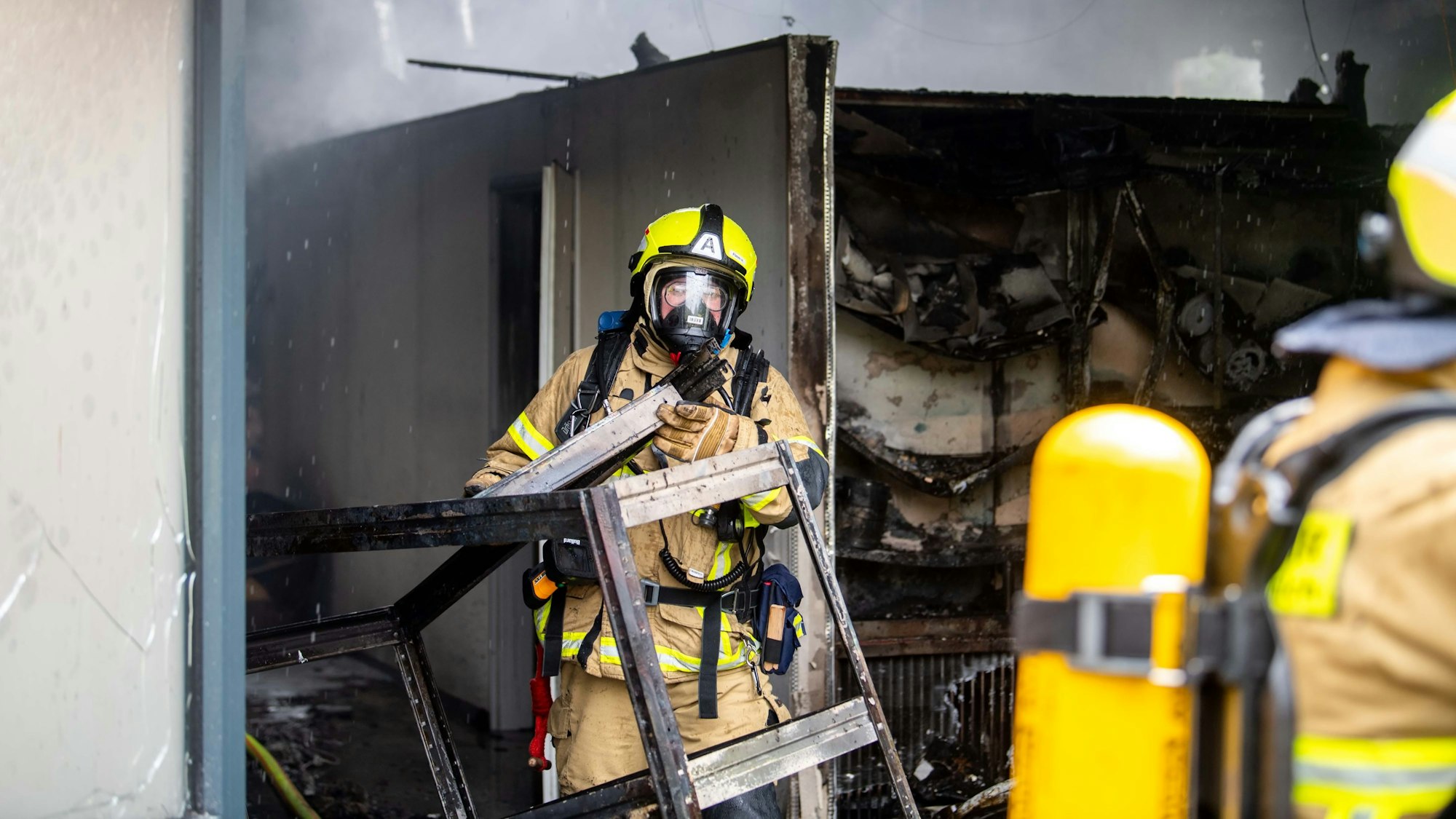 Feuerwehrleute mit Atemschutzgeräten sind am Krematorium Mechernich im Einsatz.