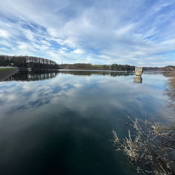 Wolken spielen sich im Wasser einer Talsperre