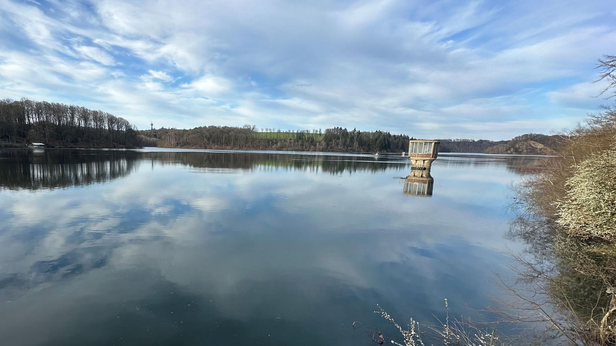 Wolken spielen sich im Wasser einer Talsperre