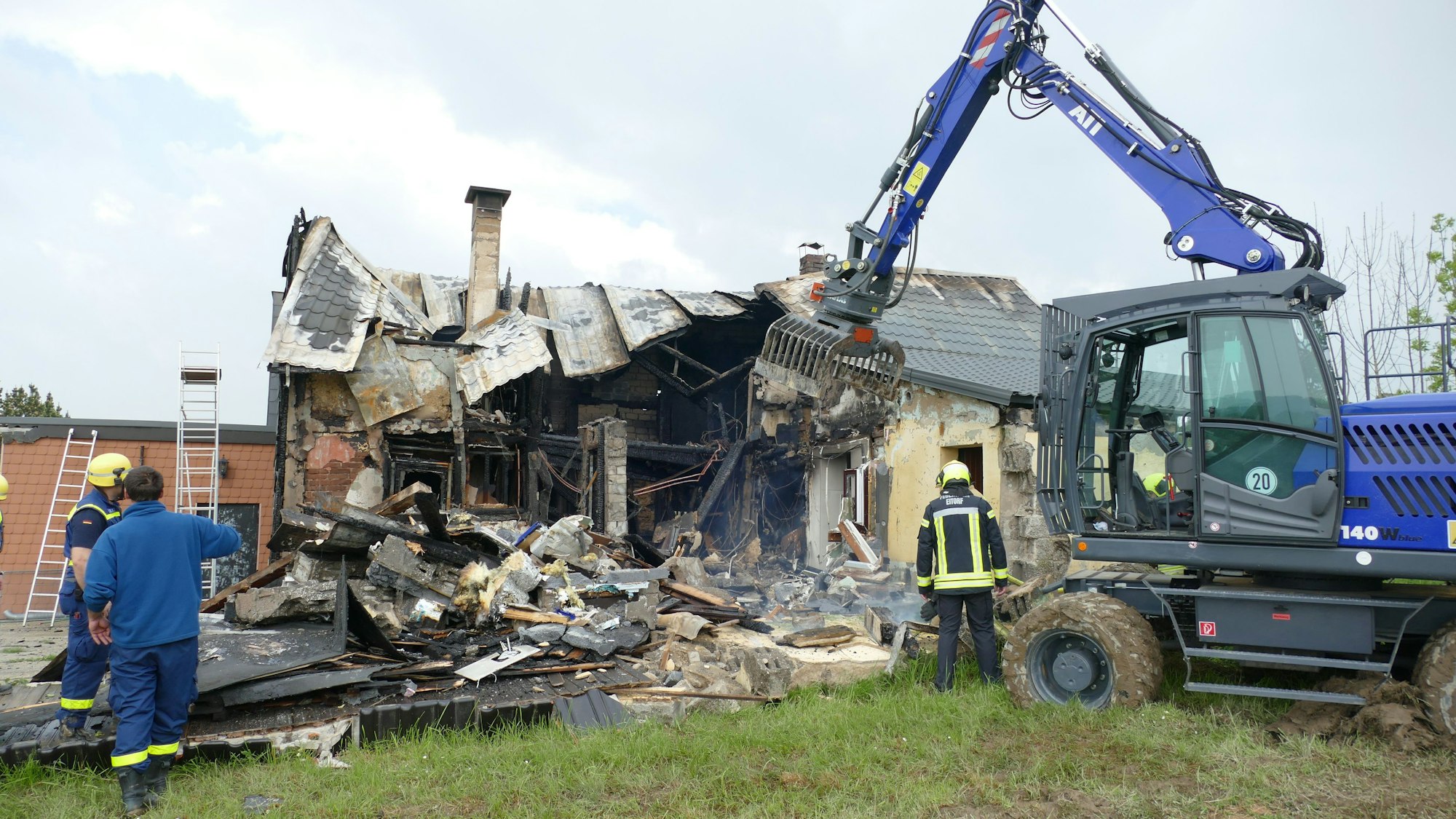Ein brennendes Haus in der Dunkelheit ist zu sehen.