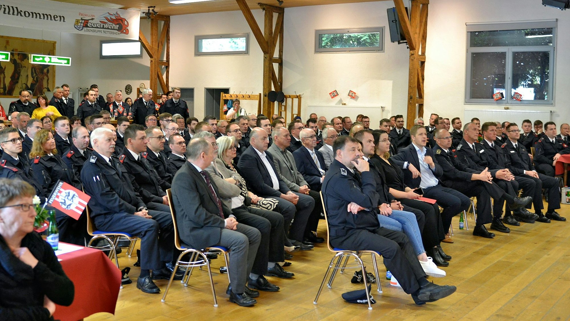 Zahlreiche Menschen sitzen in einem Saal.