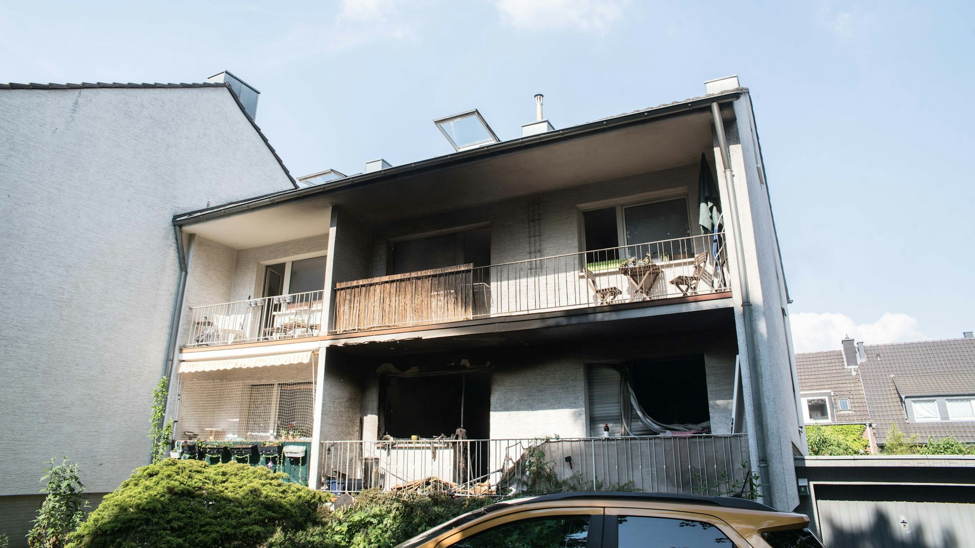 Das Foto zeigt die rußgeschwärzte Fassade eines Mehrfamilienhauses.