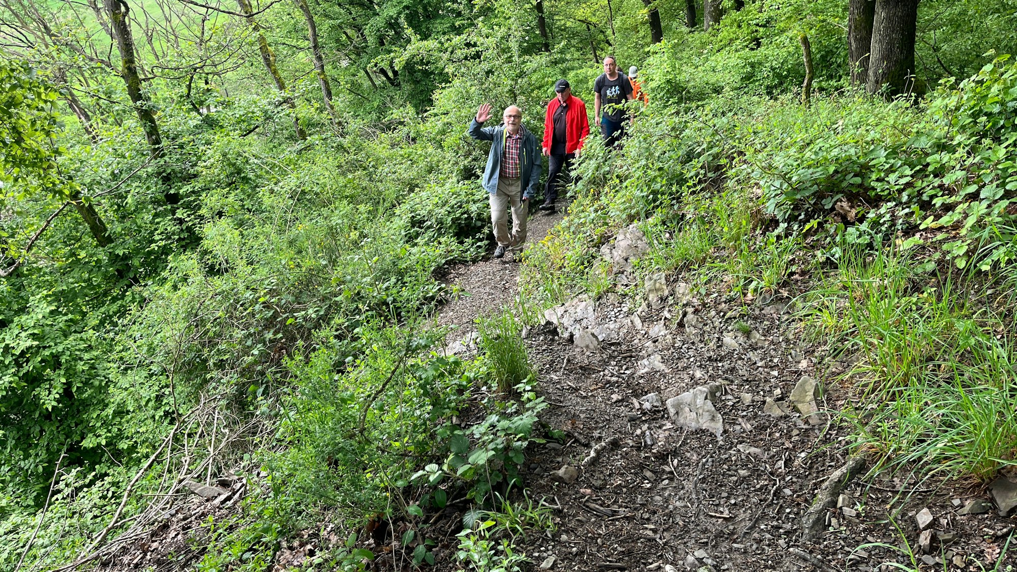 Ein Kursteilnehmer winkt beim steilen Aufstieg zur Stachelhardt in die Kamera.