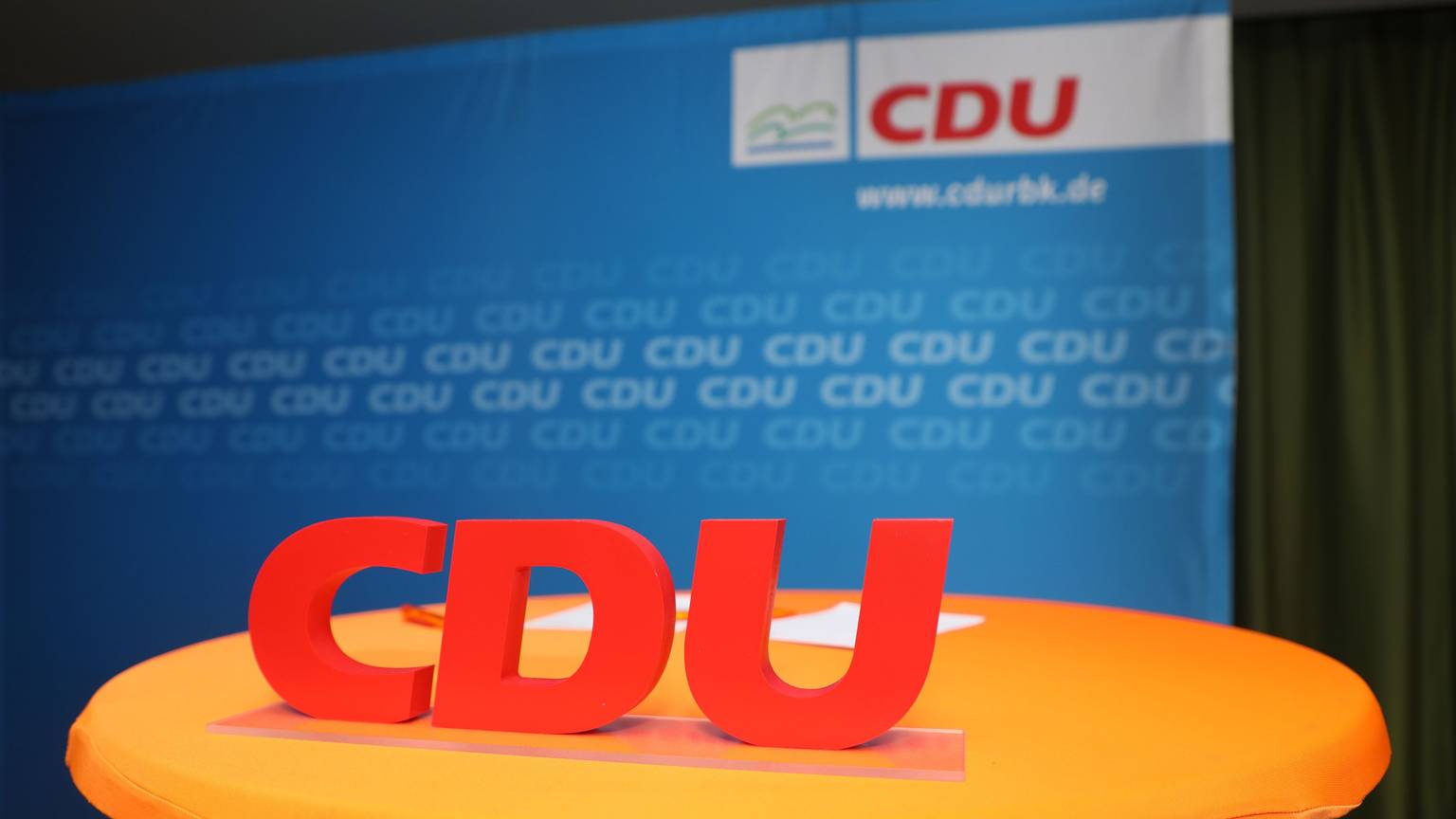 Ein CDU-Schriftzug steht vor eine Parteiwand.