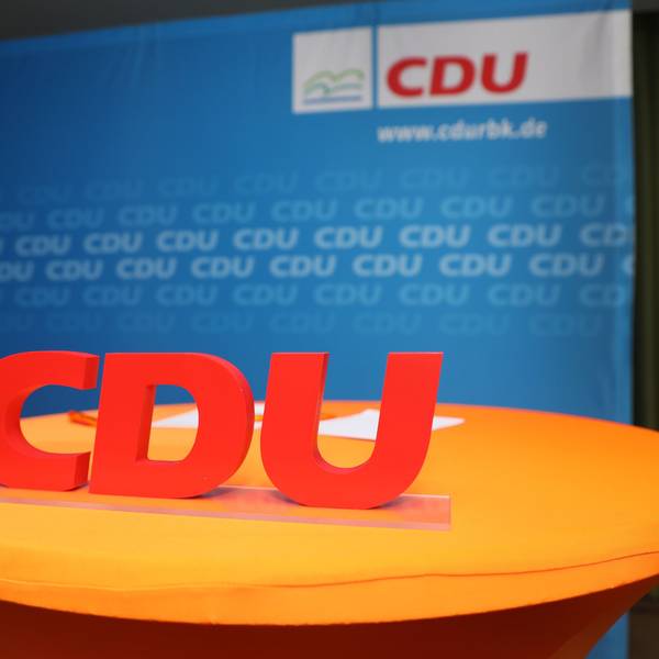Ein CDU-Schriftzug steht vor eine Parteiwand.